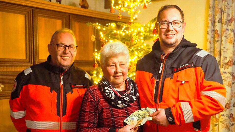 Franz Fischer (l.) und Karl Brandl dankten Helga Freimuth f&uuml;r ihre gro&szlig;herzige Spende, &uuml;bergeben vor ihrem Christbaum, dessen Schmuck sie auch selber gefertigt hat