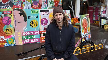 Rund 400 Wahlplakate hat Jakob Friedl gemeinsam mit anderen f&uuml;r die Kommunalwahl gemalt. Mittlerweile finden sich viele davon in den Stra&szlig;en Regensburgs wieder. Mit den bunten Plakaten wolle er auf ironische Weise ausdr&uuml;cken, dass &uuml;bliche Wahlslogans f&uuml;r ihn reine Werbekampagnen seien, sagt er.