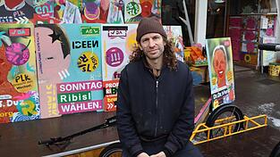 Rund 400 Wahlplakate hat Jakob Friedl gemeinsam mit anderen f&uuml;r die Kommunalwahl gemalt. Mittlerweile finden sich viele davon in den Stra&szlig;en Regensburgs wieder. Mit den bunten Plakaten wolle er auf ironische Weise ausdr&uuml;cken, dass &uuml;bliche Wahlslogans f&uuml;r ihn reine Werbekampagnen seien, sagt er.