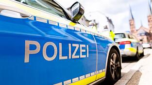 Zwei Streifenwagen der Polizei stehen am Straßenrand.