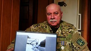 Andriy Kulish mit einem Foto, das ihm zu Beginn des Einsatzes am Ortsausgang von Tschernobyl zeigt.