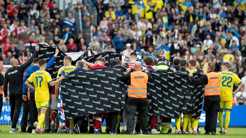 Die Spieler aus Dänemark und der Ukraine schirmen Christian Eriksen nach seinem Zusammenbruch ab. Die Spieler aus Dänemark und der Ukraine schirmen Christian Eriksen nach seinem Zusammenbruch ab.