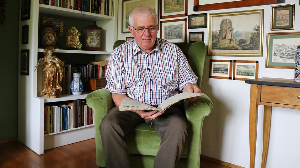 Hans Wrba bl&auml;ttert im Pemflinger Sitzungsprotokoll aus dem 19. Jahrhundert. Darin aufgelistet sind die Ma&szlig;nahmen, um die Ruhr einzud&auml;mmen.