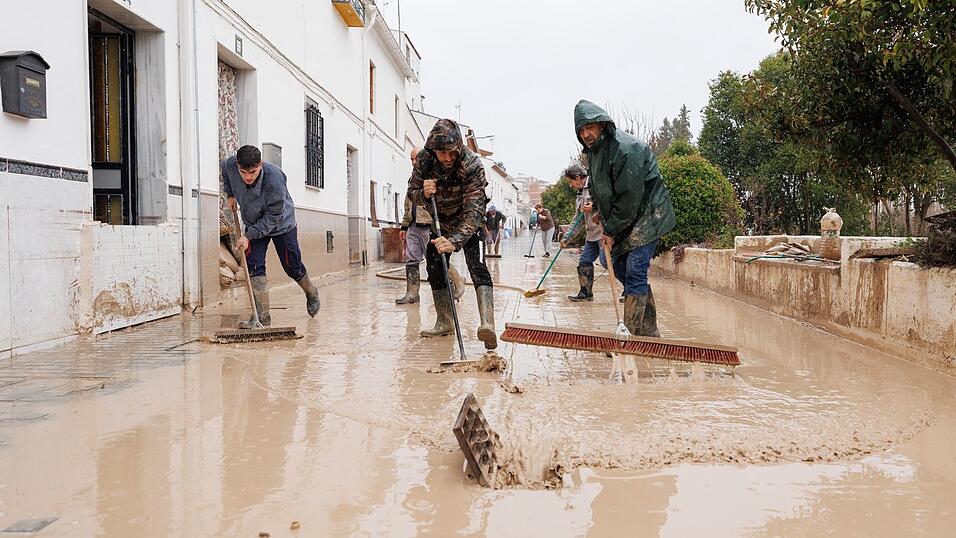 Menschen im s&uuml;dspanischen Andalusien reinigen Stra&szlig;en nach dem Sturmtief 'Leonardo'. Am Samstag folgte schon das n&auml;chste Atlantiktief 'Marta'.