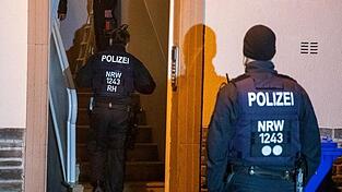 Einsatzkräfte der Polizei durchsuchen ein Mehrfamilienhaus in Essen.