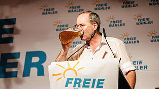 Hubert Aiwanger, Wirtschaftsminister und Landesvorsitzender der Freien W&auml;hler in Bayern, steht beim politischen Fr&uuml;hschoppen auf der B&uuml;hne der Freien W&auml;hler und trinkt aus einem Ma&szlig;krug.