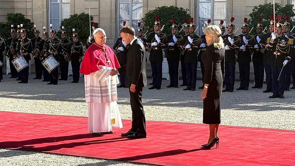 Frankreichs Präsident Emmanuel Macron und seine Ehefrau Brigitte schütteln Hände mit dem Papst im Hof des Élysée-Palastes. Frankreichs Präsident Emmanuel Macron und seine Ehefrau Brigitte schütteln Hände mit dem Papst im Hof des Élysée-Palastes.