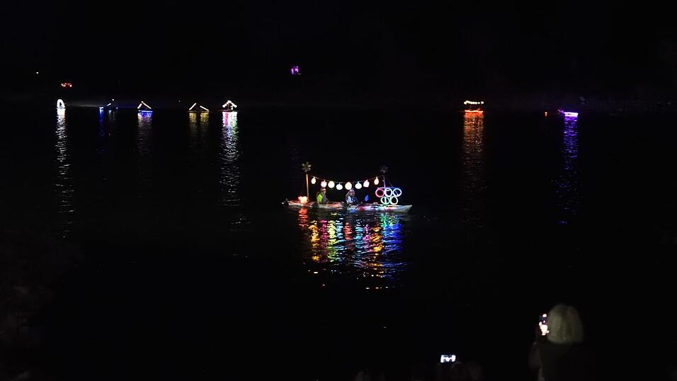 Bunt beleuchtete Boote fahren bei der Lampionfahrt über die Donau.