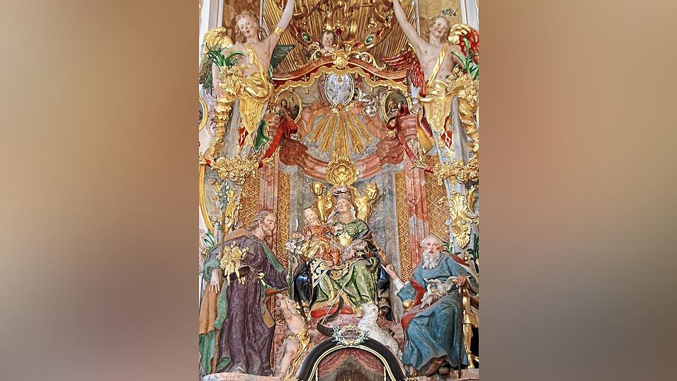 Die heilige Anna (v.l.) auf ihrem Altar in der Asambasilika in prächtiger, symbolreicher Ausgestaltung mit Mitgliedern ihrer heiligen Sippe. Der heilige Josef überreicht der kindlichen Maria als ihr zukünftiger Ehemann eine weiße Lilie als vorgezogene Anerkennung ihrer fortbestehenden Unschuld und Unbeflecktheit. Daneben der keine Jesus, als Lausbub zu Füßen seiner Großmutter in schelmischem Augenkontakt mit einem Putto im oberen Kirchenraum. Liebevoll aufmerksam betrachtet von seiner hier etwa altersgleichen späteren Mutter Maria auf dem Schoss der heiligen Anna. Ganz rechts der heilige Joachim, mit den ihm zugeteilten Attributen, den Tauben, die unter anderem für Friedfertigkeit und die Anwesenheit des Heiligen Geistes stehen. Die heilige Anna (v.l.) auf ihrem Altar in der Asambasilika in prächtiger, symbolreicher Ausgestaltung mit Mitgliedern ihrer heiligen Sippe. Der heilige Josef überreicht der kindlichen Maria als ihr zukünftiger Ehemann eine weiße Lilie als vorgezogene Anerkennung ihrer fortbestehenden Unschuld und Unbeflecktheit. Daneben der keine Jesus, als Lausbub zu Füßen seiner Großmutter in schelmischem Augenkontakt mit einem Putto im oberen Kirchenraum. Liebevoll aufmerksam betrachtet von seiner hier etwa altersgleichen späteren Mutter Maria auf dem Schoss der heiligen Anna. Ganz rechts der heilige Joachim, mit den ihm zugeteilten Attributen, den Tauben, die unter anderem für Friedfertigkeit und die Anwesenheit des Heiligen Geistes stehen.