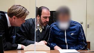 Einer der Angeklagten zusammen mit seinen Anw&auml;lten.