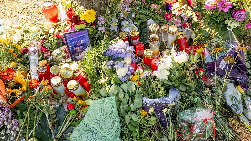 Blumen, Kerzen und Bilder liegen an einem Baum, in dessen Nähe am 17. August eine weibliche Leiche in einem Auto entdeckt wurde.