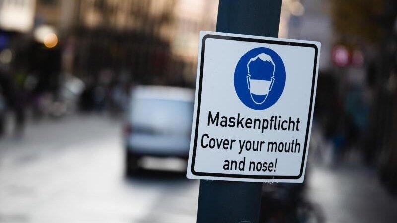 Ein Schild weist auf das Tragen einer Maske hin. Ein Schild weist auf das Tragen einer Maske hin.