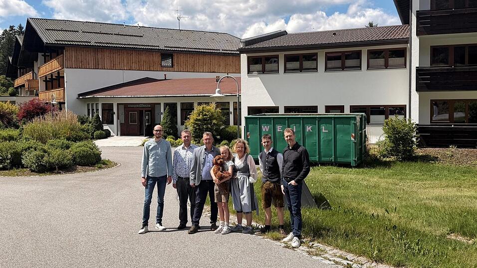 Blicken gemeinsam auf die Zukunft des bisherigen Hotels Riederin (v.l.): BTM-Gesch&auml;ftsf&uuml;hrer Tobias Wolf, B&uuml;rgermeister Michael Adam so wie die Familie Weikl mit Christian, Tochter Luisa mit Hund Rudi, Anja und Sohn Lukas sowie Franz jun.