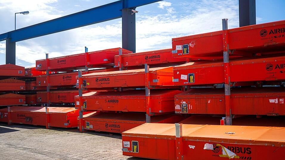 Vor der Werkhalle warten besch&auml;digte Fahrzeugteile auf die Reparatur.