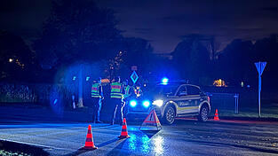 Einsatzkräfte der Polizei stehen an einer abgesperrten Straße. In Erding ist es am Mittwochabend zu einem größeren Polizeieinsatz gekommen.
