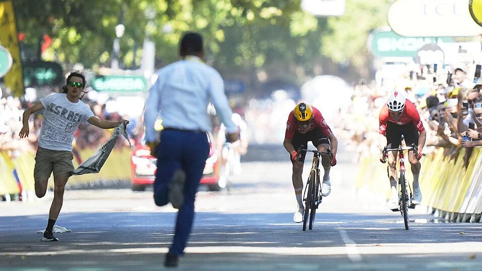 Während Jonas Abrahamsen und Mauro Schmid (r) in Toulouse um den Sieg sprinten, läuft ein Flitzer (l) auf die Zielgerade. Während Jonas Abrahamsen und Mauro Schmid (r) in Toulouse um den Sieg sprinten, läuft ein Flitzer (l) auf die Zielgerade.