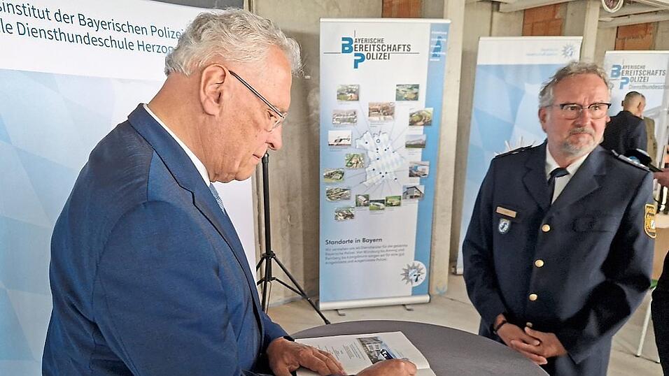 Der Innenminister trägt sich in das Gästebuch der Zentralen Diensthundeschule ein.