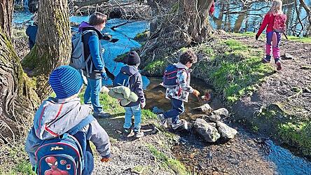 Auf Steinen &uuml;ber das Wasser springen, was gibt es f&uuml;r Kinder Sch&ouml;neres. Auch die Insel im Chamb wird auf Unrat untersucht.