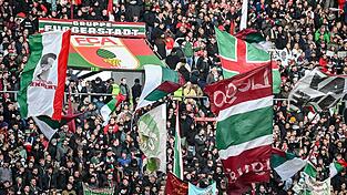 Fans des FC Augsburg schwenken ihre Fahnen in der WWK-Arena. (Archivfoto)