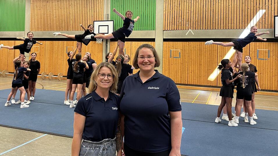 Tanja Oswald (links), eine der beiden Abteilungsleiterinnen der Cheerleader, und Coach Gabriele R&ouml;hrl mit dem Team &bdquo;Danger&ldquo; (dt.: Gefahr). Die M&auml;dchen zeigen einen &bdquo;Liberty Arabesque&ldquo;.