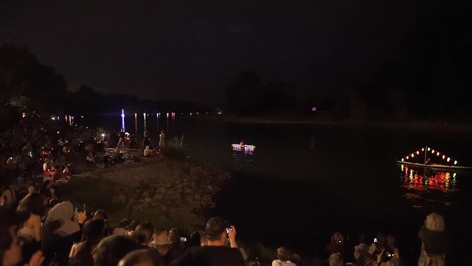 Bunt beleuchtete Boote fahren bei der Lampionfahrt über die Donau.