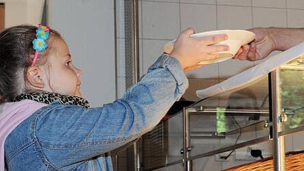 Eine Sch&uuml;lerin bekommt in einer Schulmensa Essen. Glutenfrei ist noch selten zu finden.