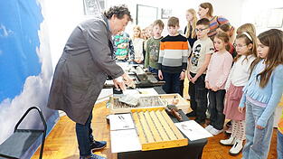 Horst Pinsker bringt die Namen des jeweiligen Kindes mittels Handdruckpresse und Druckfarbe auf DIN A5-Karten mit den Morgenstern-Gedichten auf. Fotos: