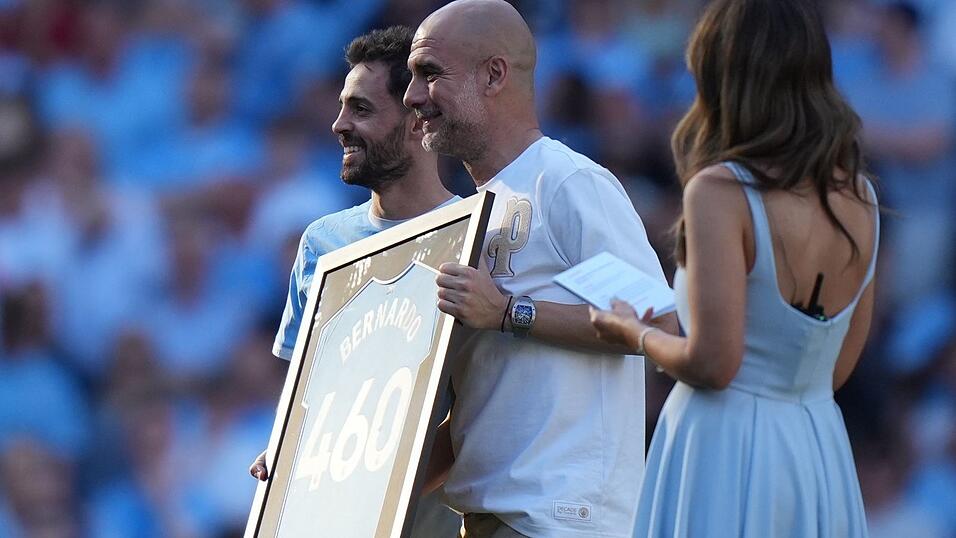 Bernardo Silva (l) und Trainer Pep Guardiola während einer Zeremonie nach ihrem letzten Spiel für Manchester City. Bernardo Silva (l) und Trainer Pep Guardiola während einer Zeremonie nach ihrem letzten Spiel für Manchester City.
