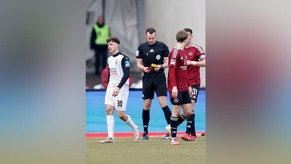 Ulms Maurice Krattenmacher (l) sieht Gelb-Rot nach einer Schwalbe im Strafraum.