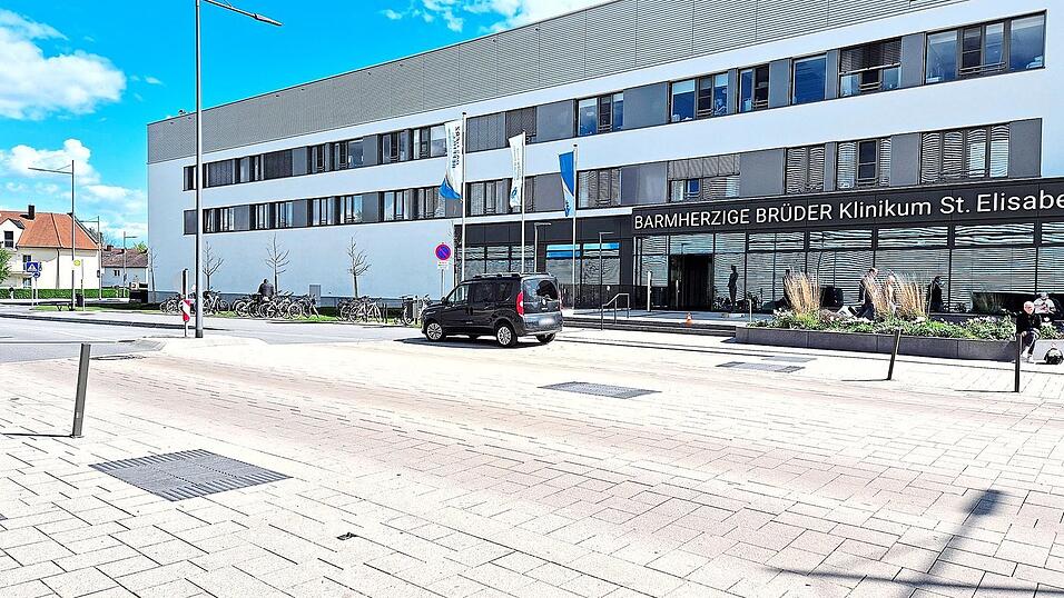 Platz oder Stra&szlig;e? Autofahrer und Fu&szlig;g&auml;nger tun sich offensichtlich schwer bei der richtigen Einordnung. Es handelt sich aber um eine Stra&szlig;e mit eingebauter Querungshilfe f&uuml;r Fu&szlig;g&auml;nger, Autos haben hier Vorrang. Ein kleiner dunkler Fleck im hellen Pflaster deutet die Mitte der Querungshilfe an. Autofahrer d&uuml;rfen an ausgewiesenen Stellen kurz halten, aber nicht parken - dass sie es dabei nicht immer so genau nehmen, zeigen auch die schief gedr&uuml;ckten Absperrpfosten.