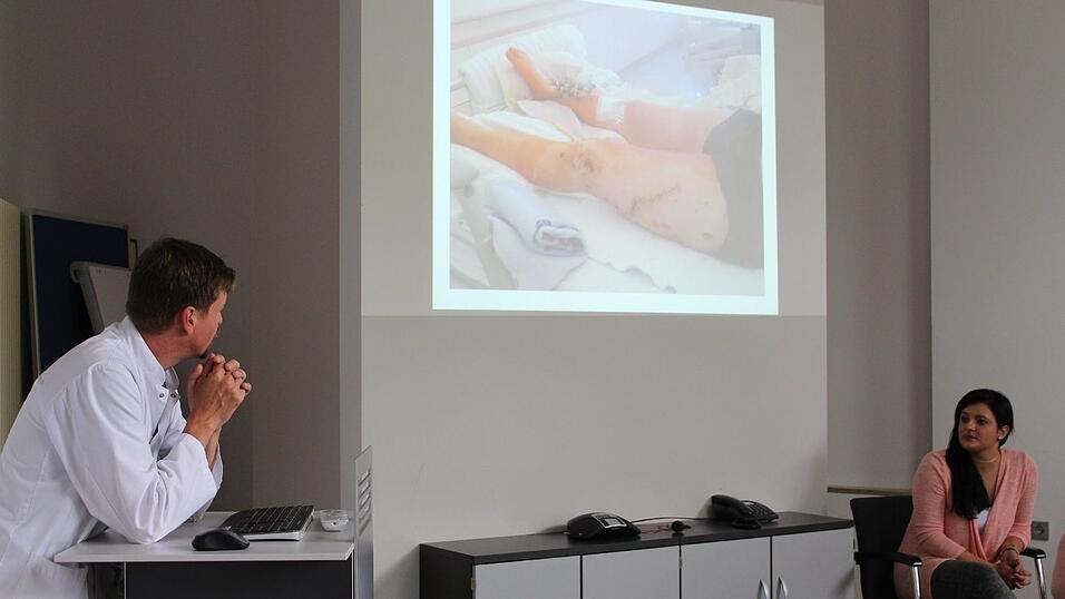 Cassandra Gro&szlig;e blickt auf die Leinwand, auf der ihre schwerverletzten Beine zu sehen sind.