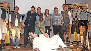 Seyfriedus Freiherr von Fraunberg liegend zu F&uuml;&szlig;en der von ihm auf die Schippe genommenen Marktr&auml;te.