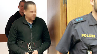 Polizeibeamte führen den Angeklagten in den Gerichtssaal. 