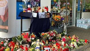 Blumen und Kerzen sind vor der Aral-Tankstelle in Idar-Oberstein aufgestellt.
