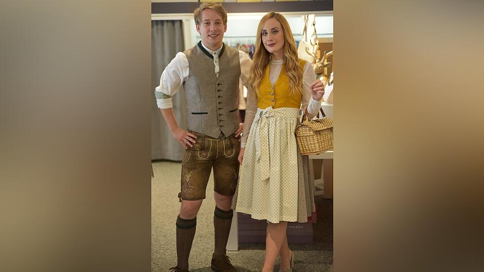 Das senfgelbe Dirndl trägt man beispielsweise in Kombi mit einer langärmeligen Spitzenbluse. Das Outfit in Lederhose & Co. ist farblich abgestimmt.