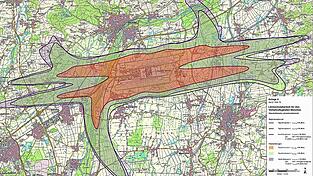 Der geplante L&auml;rmschutzbereich untergliedert sich in Tagschutzzone 1 (rotbraun), Tagschutzzone 2 (gr&uuml;n) und Nachtschutzzone (violett).