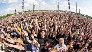 Besucher beim Open-Air-Festival 'Rock im Park' nehmen an einem Konzert teil.