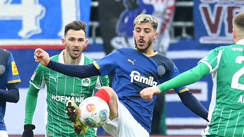 Der Kieler Umut Tohumcu (M) behauptet den Ball.