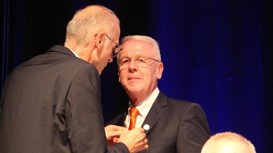 Albert Griebl, Bezirkspr&auml;sident Niederbayern des Genossenschaftsverbands Bayern (GVB), heftet Carsten Clemens die Goldene Ehrennadel des GVB an.