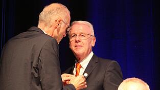Albert Griebl, Bezirkspr&auml;sident Niederbayern des Genossenschaftsverbands Bayern (GVB), heftet Carsten Clemens die Goldene Ehrennadel des GVB an.